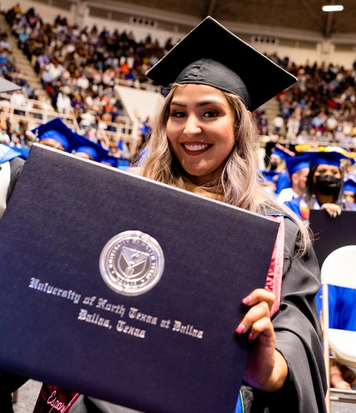 masters graduate holding diploma